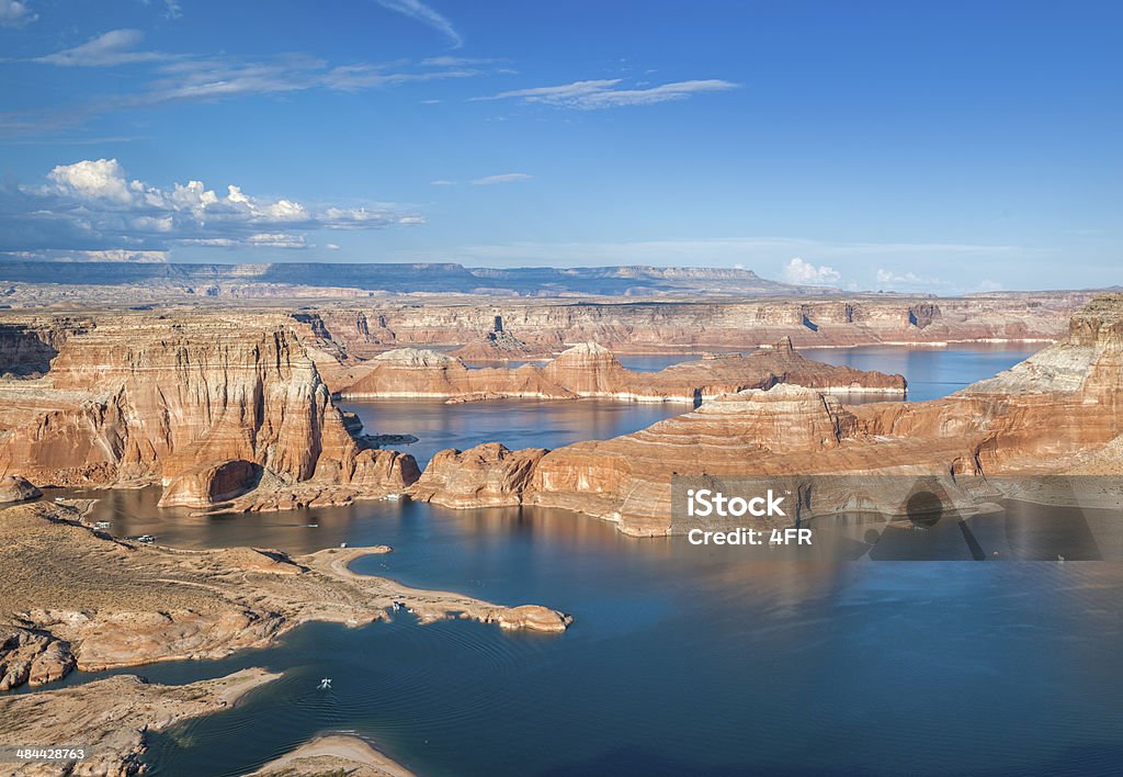 Sun setting over Lake Powell with Houseboats The stunning beautiful Lake Powell with the warm evening sun hitting the red rocks. Houseboats below. Lake Powell Stock Photo