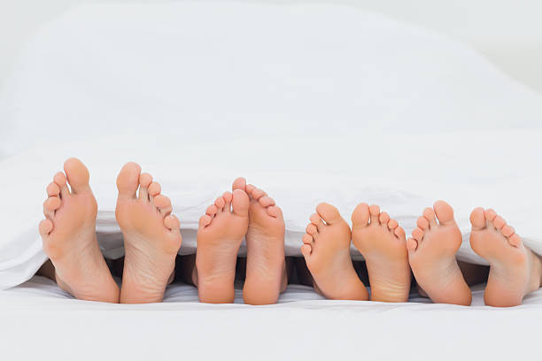 istock Family on the bed showing their feet 484431941
