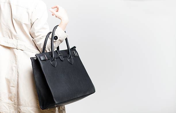 istock Fashionable woman with black bag, back view 484432979