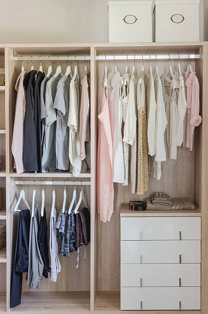 istock clothes hanging in wooden wardrobe 484438814