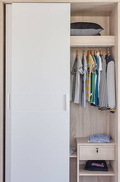 istock kid's clothes hanging in white wardrobe 484441274
