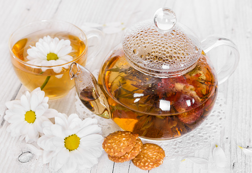 Chinese flowering tea with camomile and cookies on a wooden background