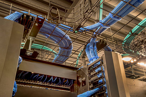 Overhead Cable Trays with Cat 5 Wires Cable trays in a data center with cat 5 and optic fiber cables. computer cable stock pictures, royalty-free photos & images