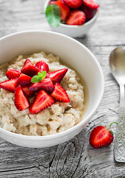 istock oatmeal with honey and strawberries in a white bowl 484450204