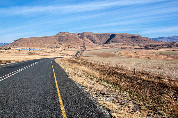 istock Long Asphalt Road Stretching through Dry Winter Landscape 484452364