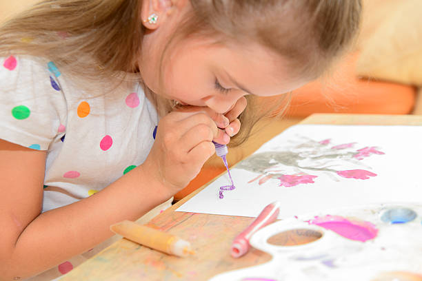 Hands of a small child starting to paint a white canvas with his hands. Creative activity and development of the senses.