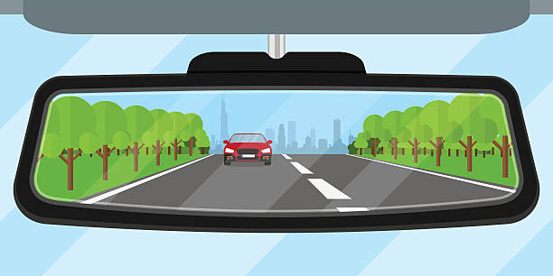 car mirror picture of a car rear view mirror reflected road, another car, trees and big city silhouette, flat style illustration vista posterior stock illustrations