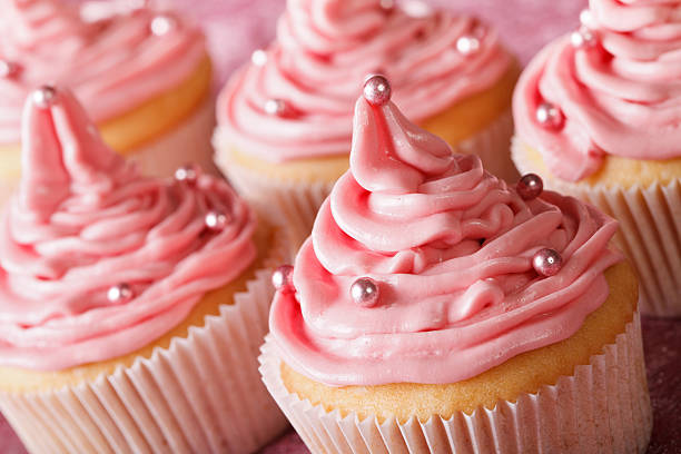 istock Delicate festive cupcakes with pink cream macro. horizontal 484460236