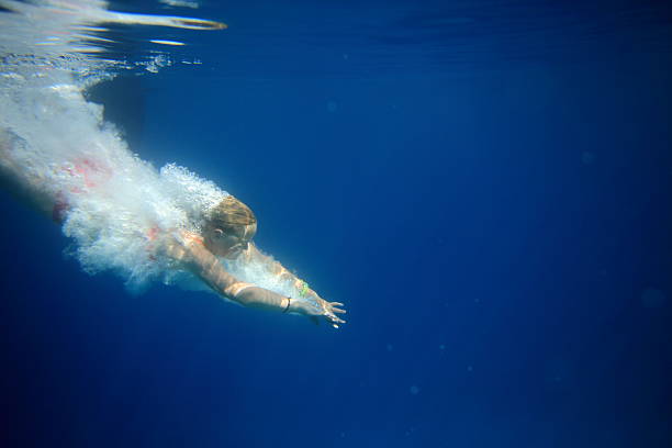 istock girl diving into crystal clear water 484463420