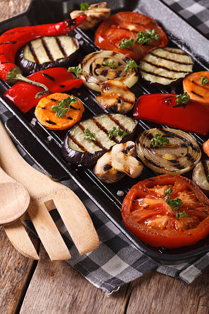 istock vegetables: peppers, tomato, onion,  in pan grill. Vertical 484465696