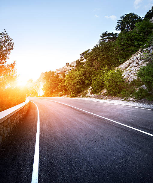 istock Asphalt road in summer forest at sunset. Crimean mountains 484467696