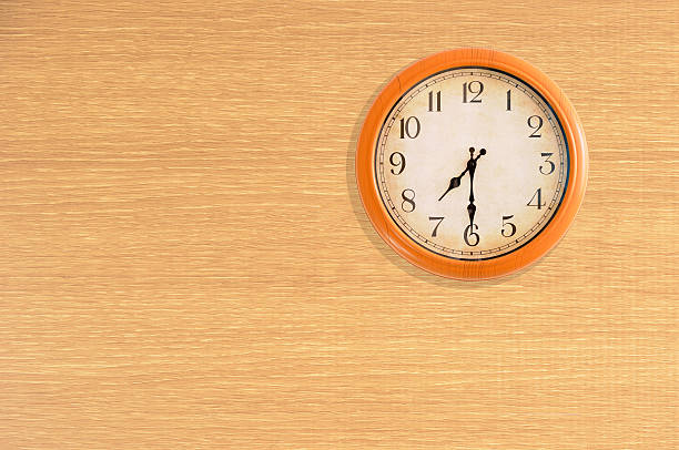 istock Clock showing 7:30 o'clock on a wooden wall 484468142