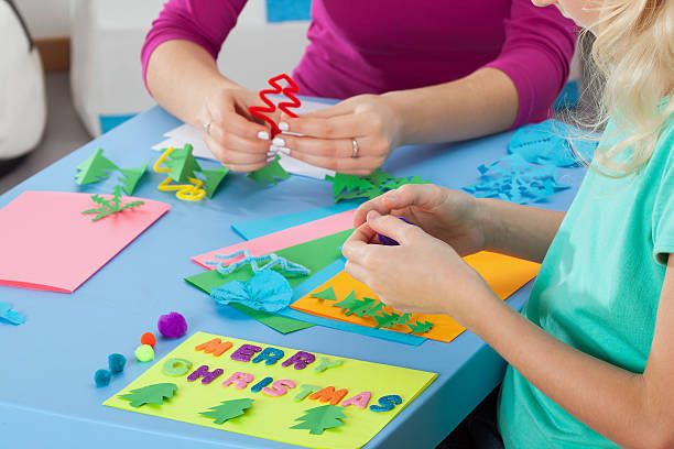 istock Little girl making crafts with teacher 484468937
