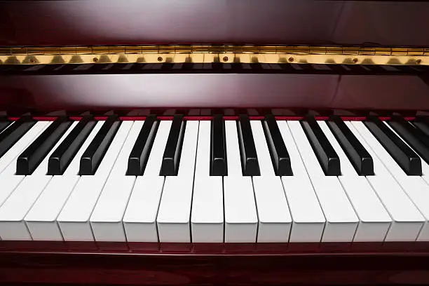 Photo of ebony and ivory keys of red piano