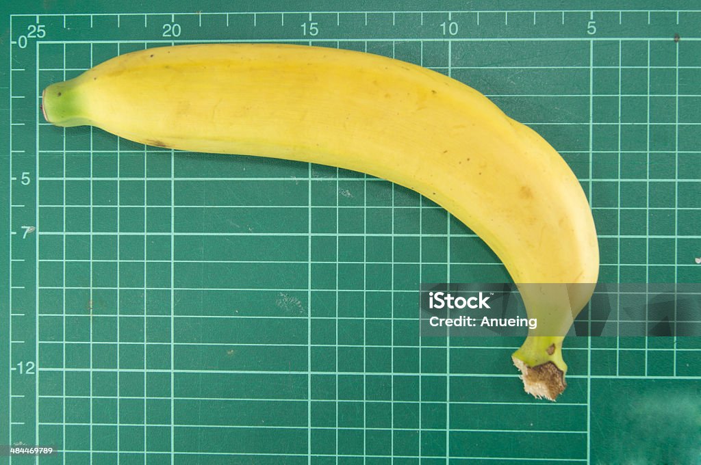 Banana with cutting mat on white background Banana on cutting mat on white background Abstract Stock Photo