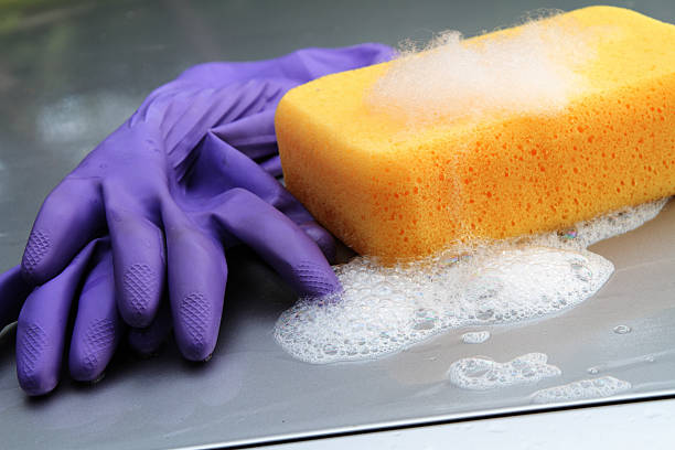 istock Soapy sponge and rubber gloves on car hood 484471820