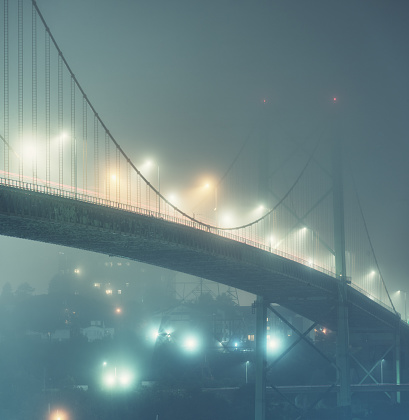 Fog enshrouds the A. Murray MacKay suspension bridge spanning Halifax Harbour.  Long exposure.