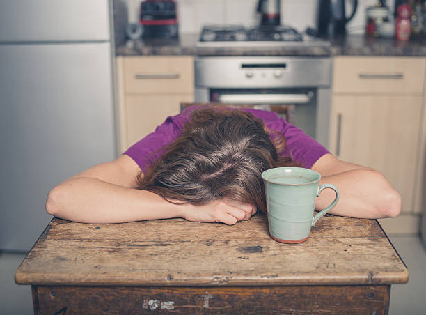 istock Tired woman with tea in kitchen 484472516