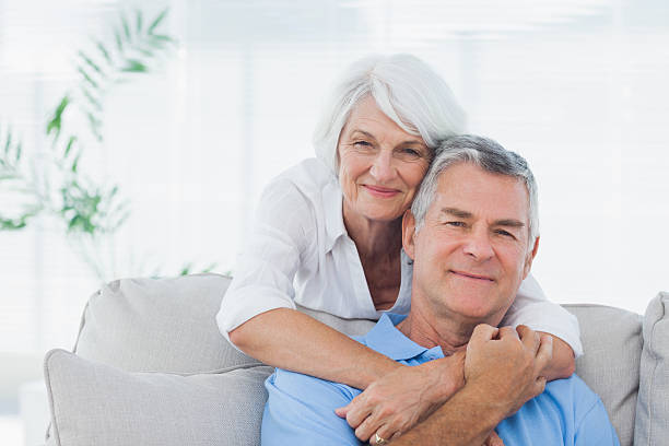istock Woman embracing husband who is sitting on the couch 484473233