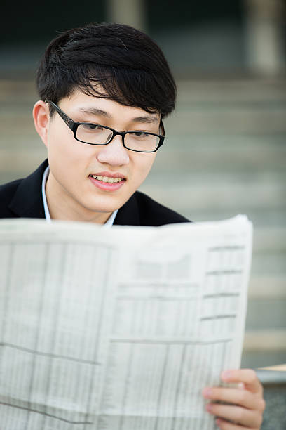 istock Young businessman reading newspaper 484475491