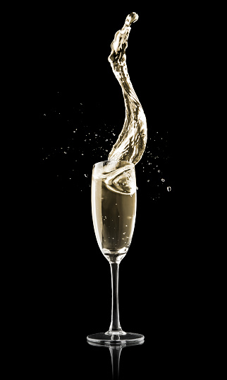 An elegant glass of Champagne on a black background. 