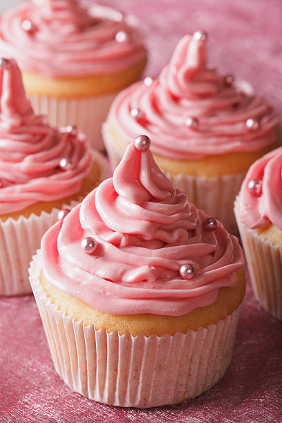 istock Delicate festive cupcakes with pink cream close-up, vertical 484481278