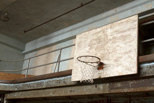 Basketball backboard and net in old school gym.