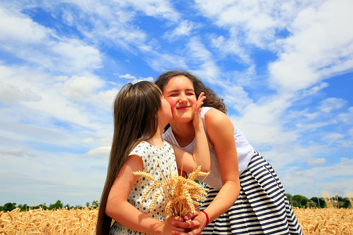 Happy family moments - Young girls having fun ln the wheat field