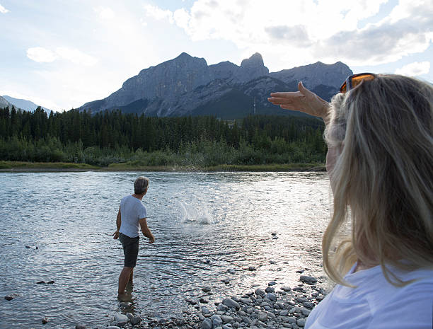 istock View past woman's face to man throwing rock into river 484487420