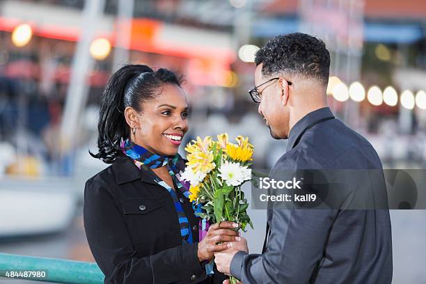Happy African American woman getting flowers
