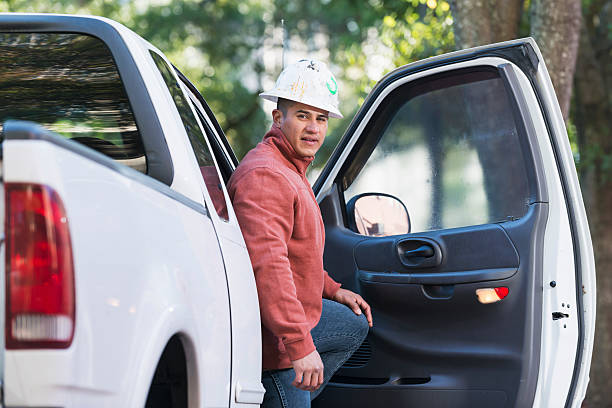 White pick-up truck and farmer with crossed arms in the field. Copy space.