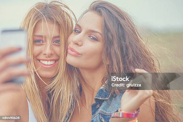 Two Cheerful Hipster Friends Taking Selfie Photos On Smart Phone Stock Photo - Download Image Now