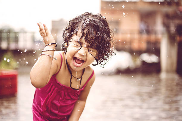 Little girl enjoying summer heavy rain