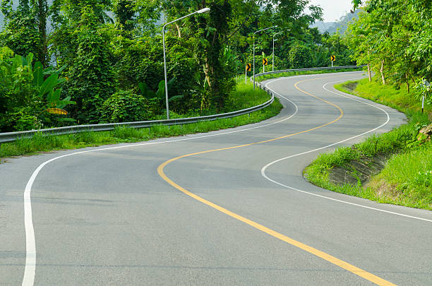 istock Asphalt road sharp curve along with tropical forest zigzag ahead. 484514497