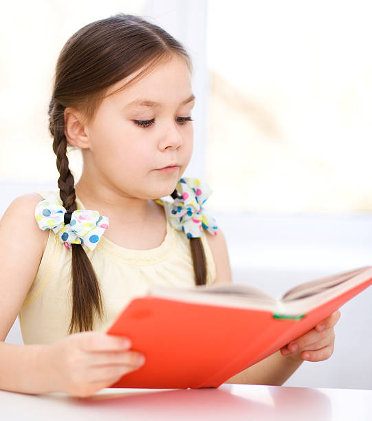 istock Little girl is reading a book 484516391