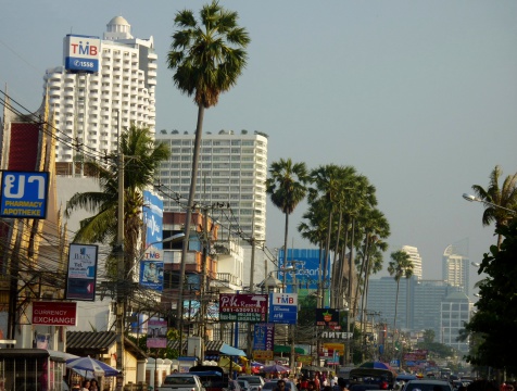 Jomtien, Thailand - January 01, 2013: crowd of tourists and cars on Jomtien beach promenade. In the background, tall Hotel buildings and apartments.