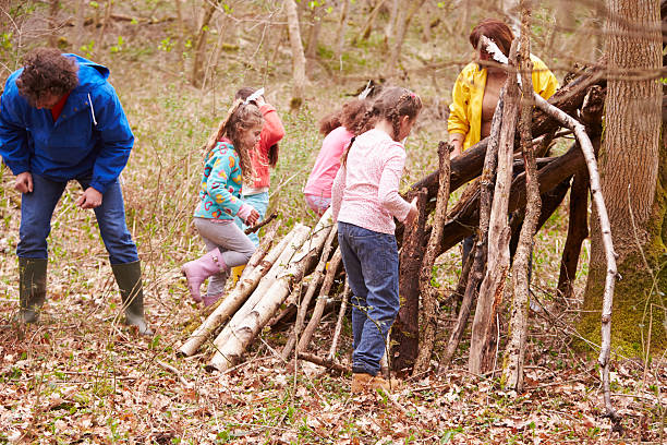 istock Adults And Children Building Camp At Outdoor Activity Centre 484517050