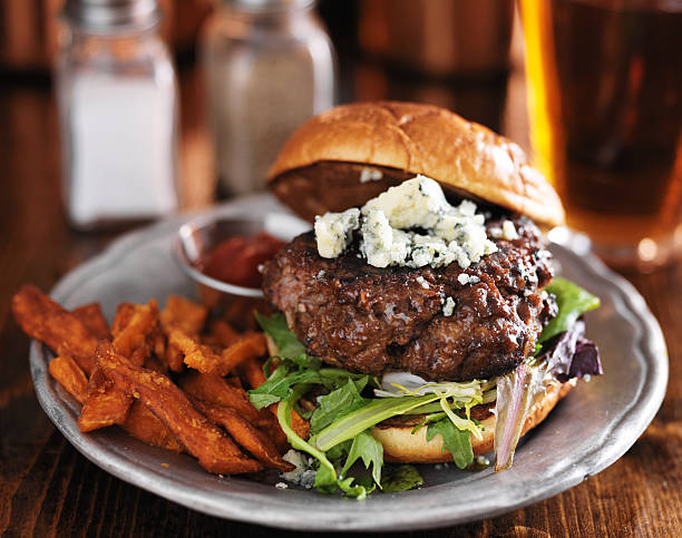 thick burger with blue cheese and sweet potato fries gourmet hamburger with blue cheese with sweet potato fries blue cheese stock pictures, royalty-free photos & images