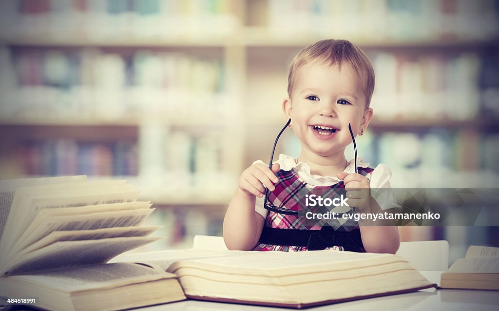 Engraçado bebê em óculos lendo um livro - Foto de stock de Aluna royalty-free