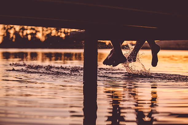 istock Loving couple at jetty (feet only) 484519151