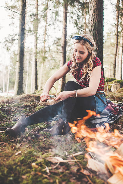 istock Woman by a campfire in the forest 484519263