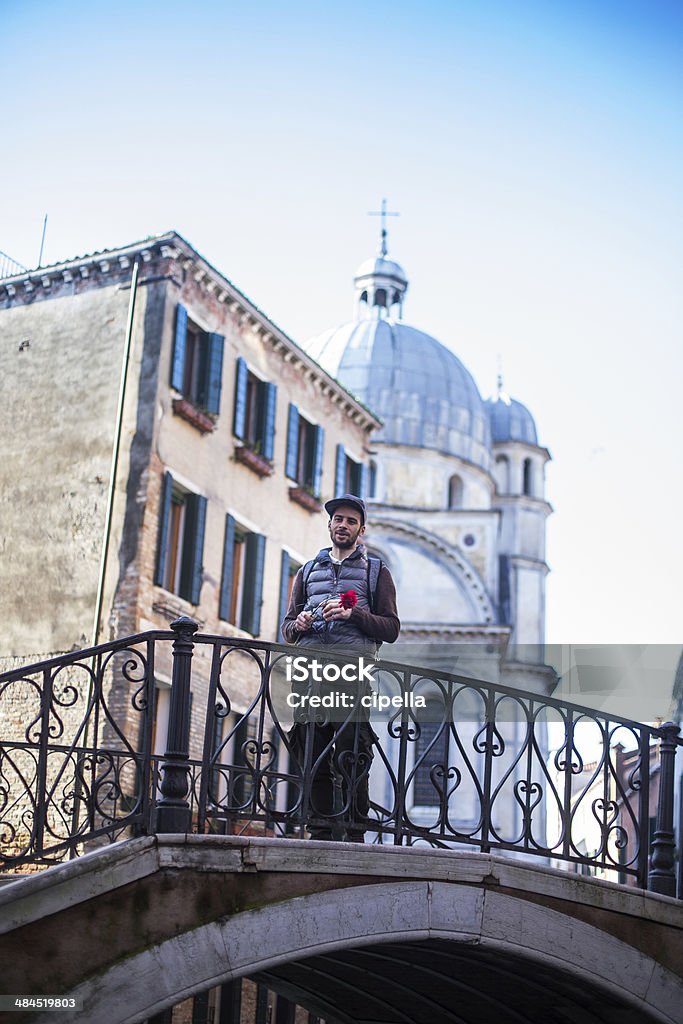 Young man with carnation Young man with carnation, standing on bridge in Venice. Adult Stock Photo