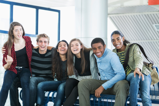 Multirracial grupo de adolescente amigos sentado en el banco photo