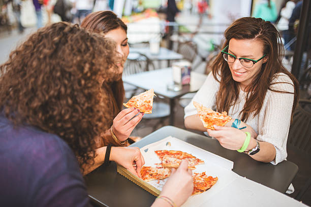 istock group of friends eating pizza togetherness 484521411