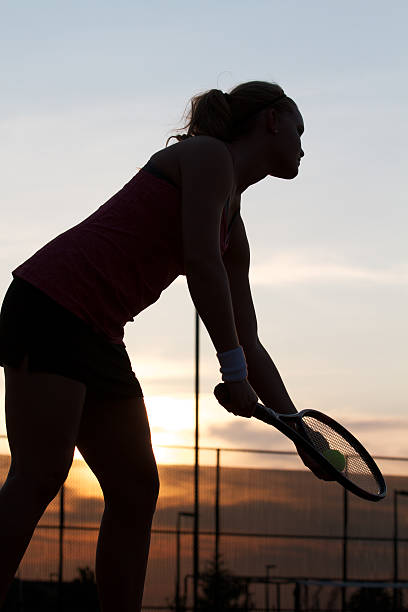 istock Shadowed Female Tennis Player Preparing to Serve 484522117
