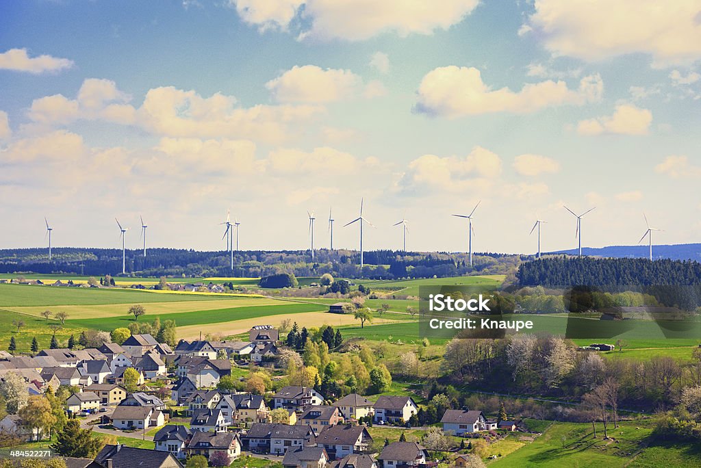 Wind turbines park behind small village in agriculture fields Horizontal Stock Photo