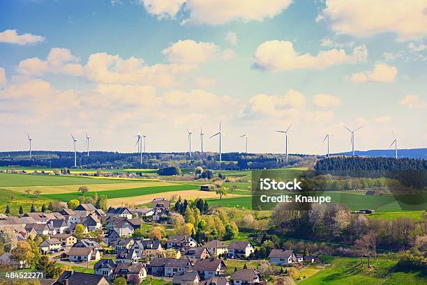 Wind Turbines Park Behind Small Village In Agriculture Fields Stock Photo - Download Image Now