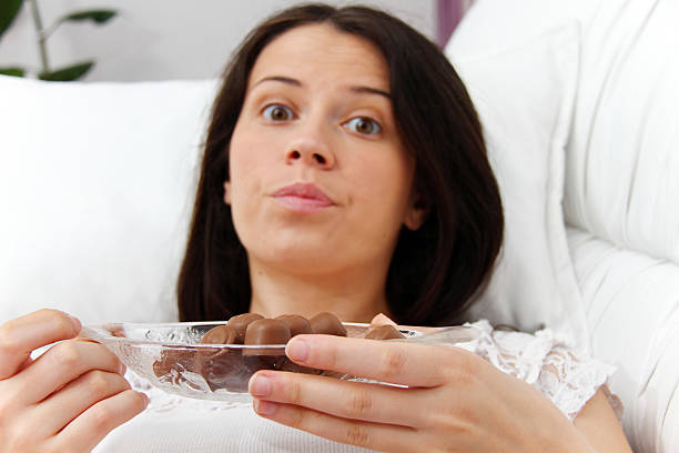 istock Pregnant woman eating chocolate 484525574