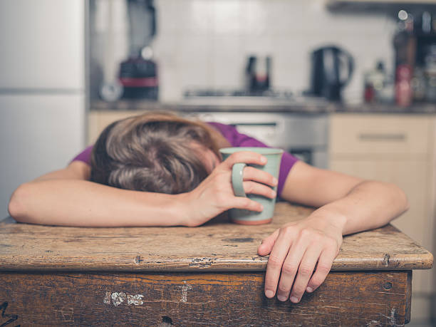 istock Tired woman with tea in kitchen 484525594