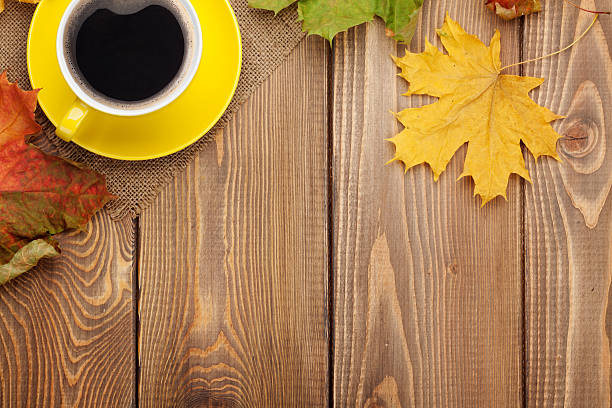istock Autumn leaves and coffee cup over wood background 484531424